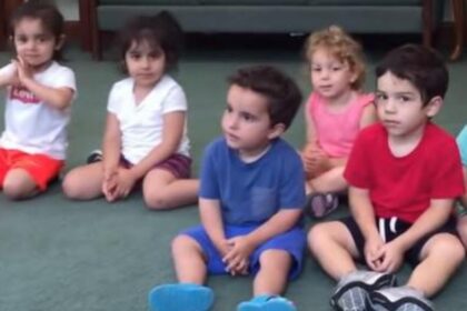 Juf vraagt aan kinderen om in hun handen te klappen - let goed op het jongetje in het blauw