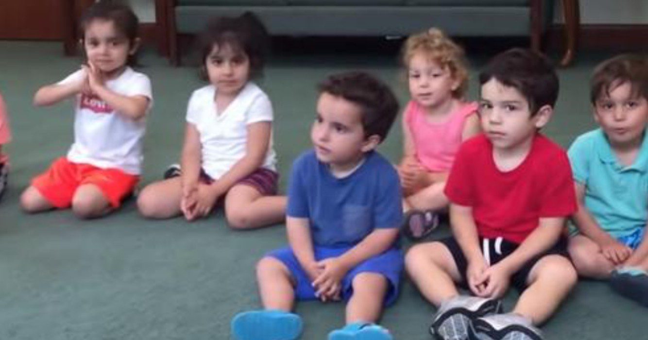 Juf vraagt aan kinderen om in hun handen te klappen - let goed op het jongetje in het blauw